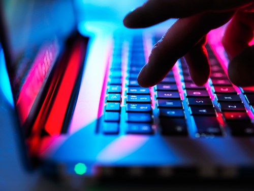 fingers typing on laptop keyboard