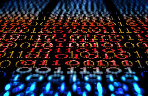 Binary code, ones and zeros in a 1970 dot matrix font on a computer screen. An infinity and lens bokeh effect applied.